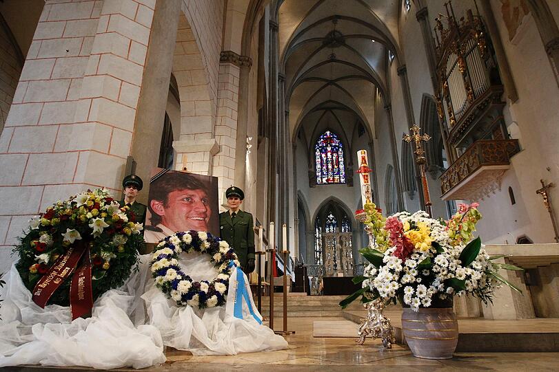 Zwei Polizistinnen neben dem Bild des Opfers im Augsburger Mariendom.