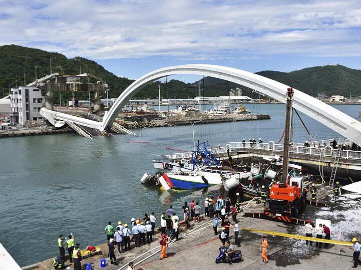 Feuerwehrleute und Rettungskräfte am Unfallort bei Nanfangao in Taiwan nach dem Einsturz einer Brücke.