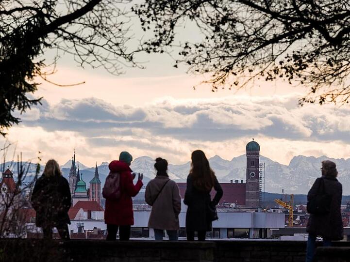 Spaziergänger auf dem Luitpoldhügel im Stadtteil Schwabing schauen auf München. Foto: Peter Kneffel/dpa