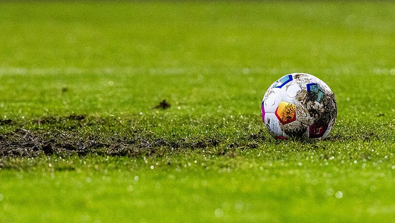 Ein Fußball liegt am Elfmeterpunkt im matschigen Rasen. Ein Fußball liegt am Elfmeterpunkt im matschigen Rasen.