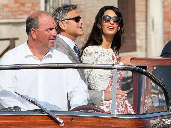 George Clooney (m.) mit seiner Frau Amal und dem Chauffeur Alessandro Greco