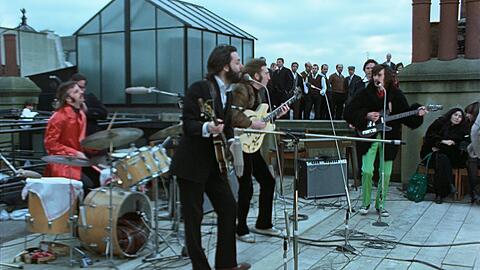 Ringo, Paul, John und George beim Konzert auf dem Dach des Apple-Gebäudes, rechts Yoko Ono.