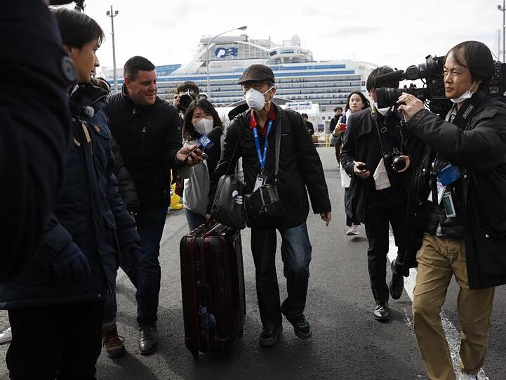 Endlich an Land: Ein Passagier wird von Journalisten empfangen, nachdem er das Kreuzfahrtschiff "Diamond Princess" verlassen hat.