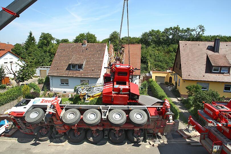 Eine Aktion, die schief ging: Als Bauarbeiter einen Kran über einen Mauer heben wollten, kippte das Fahrzeug um.