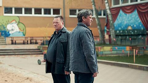 "Polizeiruf 110: Der Dicke liebt": Henry Koitzsch (Peter Kurth) und Michael Lehmann (Peter Schneider) auf dem Schulhof der Otto-Möhwald-Schule.