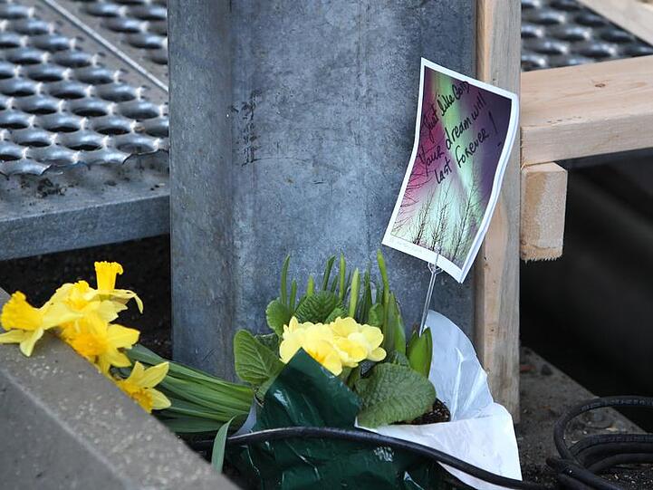 Eine Postkarte und Blumen liegen an der Stelle, an der Nodar Kumaritashvili verunglückte.