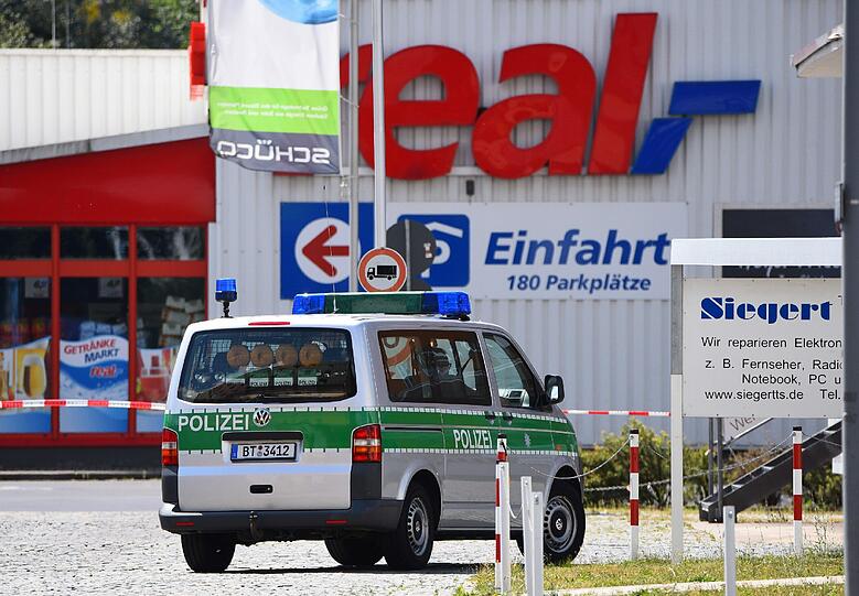 Ein Polizeiauto fährt am 25.07.2015 in Bayreuth in Richtung eines real-Supermarktes. Der Fund eines Koffers führte in dem Supermarkt zu einem Bombenalarm.