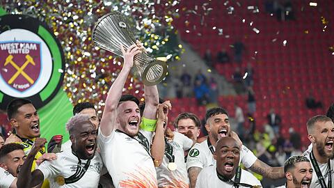 Declan Rice streckt die Trophäe in die Höhe und feiert den Sieg in der UEFA Conference League gemeinsam mit seinen Teamkollegen.