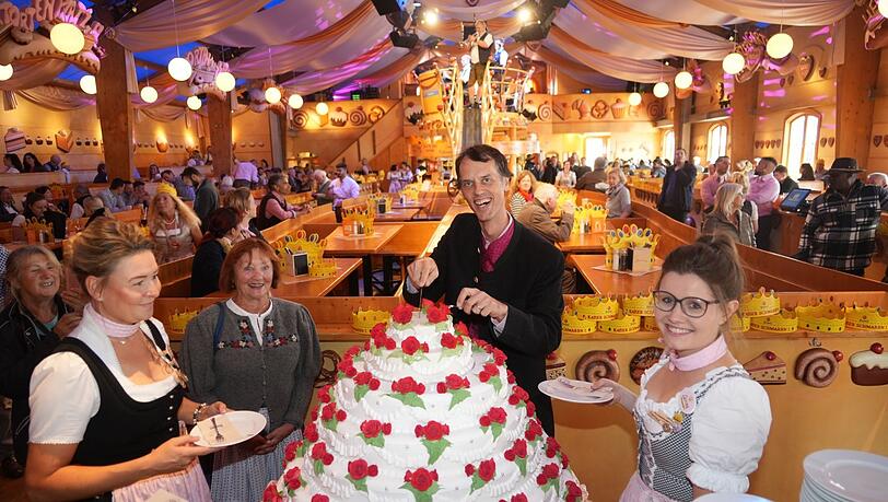 Stammgast Maria Bierl (2.v.l.) wartet auf das erste Stück Torte von Magnus Müller-Rischart.