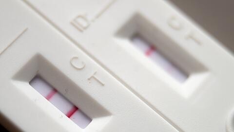 Corona-Schnelltests mit positivem (l) und negativem Ergebnis liegen auf einem Tisch.