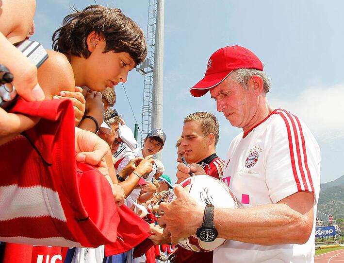 Trainer Jupp Heynckes schreibt Autogramme.
