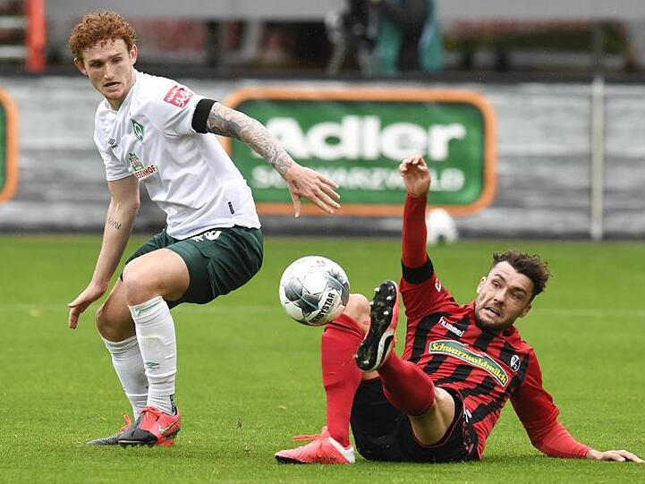 Freiburgs Manuel Gulde (r) kämpft mit Bremens Josh Sargent um den Ball.