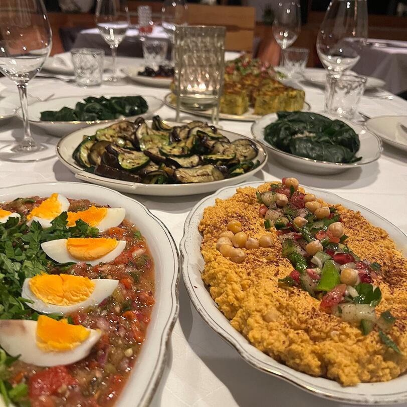 Die Gerichte werden auf die lange Tafel gestellt, jeder kann davon probieren.