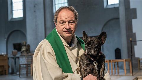 Pfarrer Rainer Maria Schießler mit seiner Hündin Pia in der St. Maximilian Kirche in München.