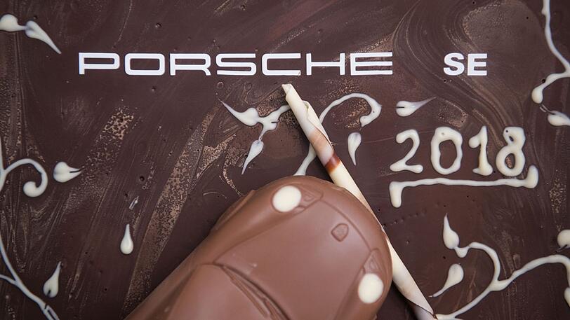 Ein Porsche SE-Schriftzug und ein Schokoladenporsche sind auf einem Dessert-Arrangement nach der Bilanzpressekonferenz der Porsche SE zu sehen. Die Rekordzahlen von Volkswagen haben auch dem VW-Hauptaktionär Porsche SE ein dickes Plus eingebracht.