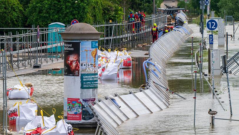 Mitarbeiter der Wasserwacht kontrollieren die provisorischen Schutzwände an der Donau in der Altstadt.