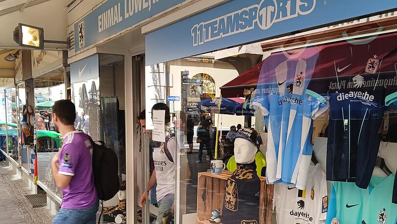 Real-Fans kommen aus dem Löwen-Fanshop am Hofbräuhaus heraus. Real-Fans kommen aus dem Löwen-Fanshop am Hofbräuhaus heraus.