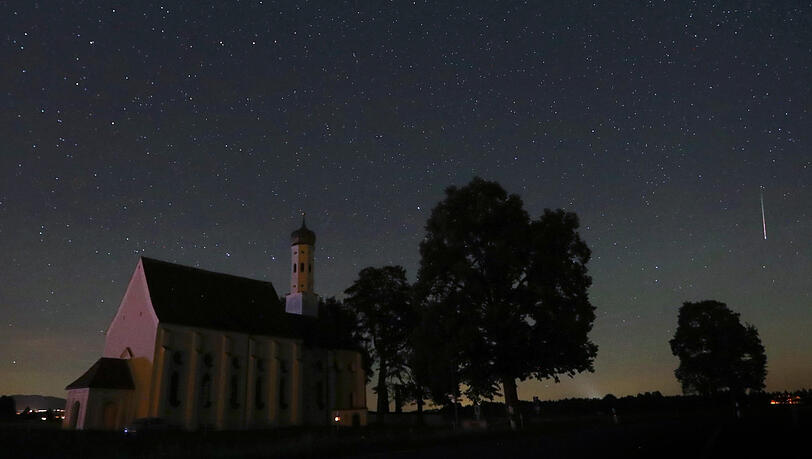 Eine Sternschnuppe verglüht am Himmel über der Wallfahrtskirche Sankt Coloman. Eine Sternschnuppe verglüht am Himmel über der Wallfahrtskirche Sankt Coloman.