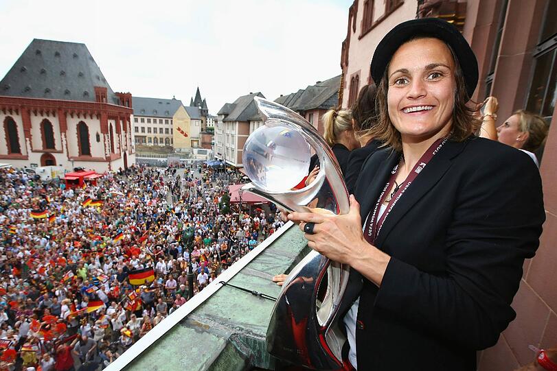 Da ist das Ding: Torhüterin Nadine Angerer, die im Spiel zwei Elfmeter gehalten hatte, mit dem EM-Pokal auf dem Balkon des Frankfurter Römer. Foto: Christof Koepsel