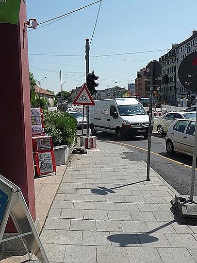 Auf der verengten Fahrbahn ist für die Radlfahrer so gut wie gar kein Platz mehr. Das Warnschild für die Autofahrer steht noch dazu falsch herum da.