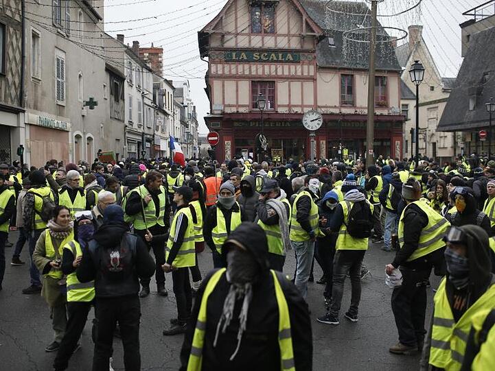 In Bourges versammeln sich Teilnehmer einer Demonstration der "Gelbwesten" auf einem Platz.