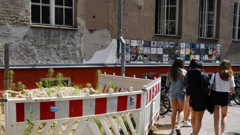 Absperrungen vor einer maroden Wand an einer Berliner Schule.