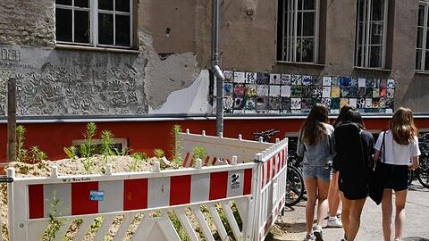 Absperrungen vor einer maroden Wand an einer Berliner Schule.