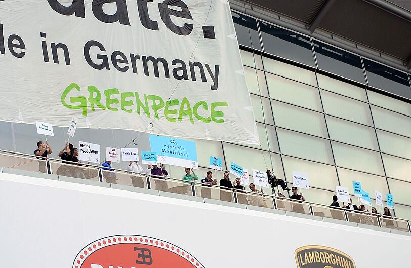 Mit Protest-Plakaten machen die Greenpeace-Aktivisten ihrem Unmut über den neuen Kleinwagen "VW Up" auf der Internationalen Automobilausstellung in Frankfurt Luft.