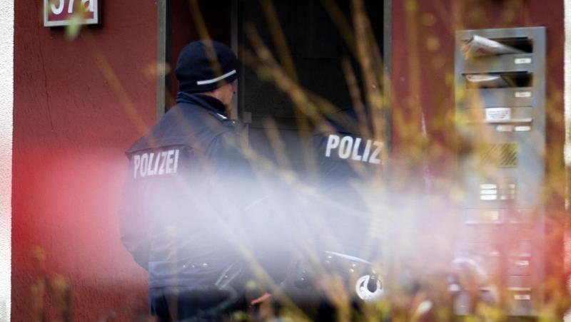 Polizeibeamte bewachen den Eingang eines Hauses, im Vordergrund flattert Polizeiabsperrband. In einer der Wohnungen wurden zwei tote Kleinkinder im Alter von ein und zwei Jahren gefunden worden. Polizeibeamte bewachen den Eingang eines Hauses, im Vordergrund flattert Polizeiabsperrband. In einer der Wohnungen wurden zwei tote Kleinkinder im Alter von ein und zwei Jahren gefunden worden.