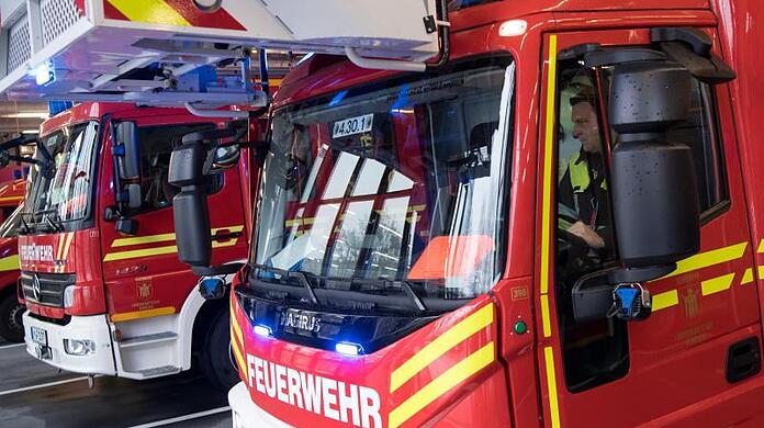Feuerwehrmänner der Berufsfeuerwehr München fahren zu einem Einsatz. Foto: Sven Hoppe