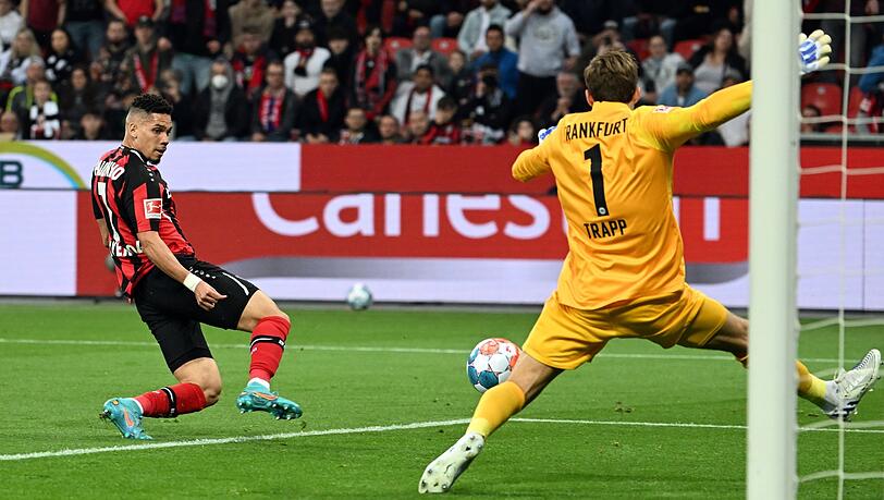 Leverkusens Paulinho (l) erzielt das 1:0 gegen Frankfurts Torhüter Kevin Trapp .