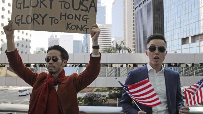 Demonstranten halten amerikanische Flaggen und ein Plakat mit der Aufschrift "Glory to USA, Glory to Hong Kong" ("Ruhm für die USA, Ruhm für Hong Kong") hoch. Demonstranten halten amerikanische Flaggen und ein Plakat mit der Aufschrift "Glory to USA, Glory to Hong Kong" ("Ruhm für die USA, Ruhm für Hong Kong") hoch.