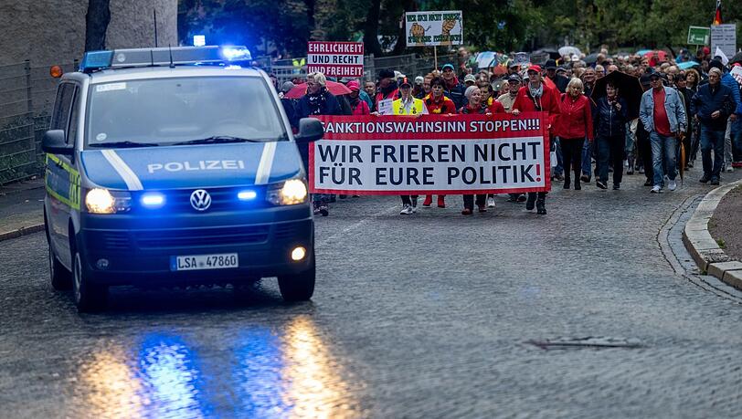 Teilnehmer einer Demo des Bündnisses "Bewegung Halle" ziehen durch Halle/Saale. Mit dabei ein Banner mit der Aufschrift: "Wir frieren nicht für eure Politik!"
