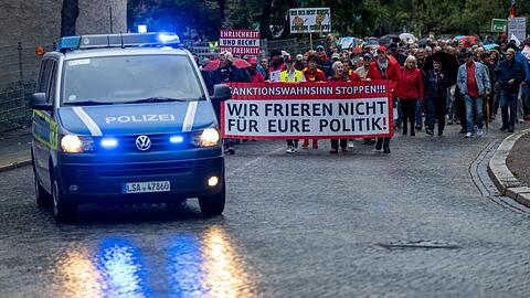 Teilnehmer einer Demo des Bündnisses "Bewegung Halle" ziehen durch Halle/Saale. Mit dabei ein Banner mit der Aufschrift: "Wir frieren nicht für eure Politik!"