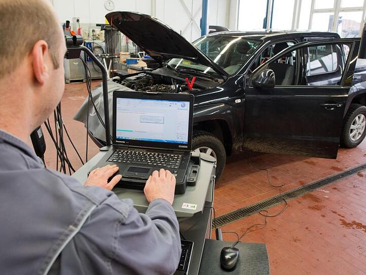 Ein Kfz-Meister lädt ein Software-Update für das Steuergerät der Motorelektronik auf einen Volkswagen Amarok mit Dieselmotor.