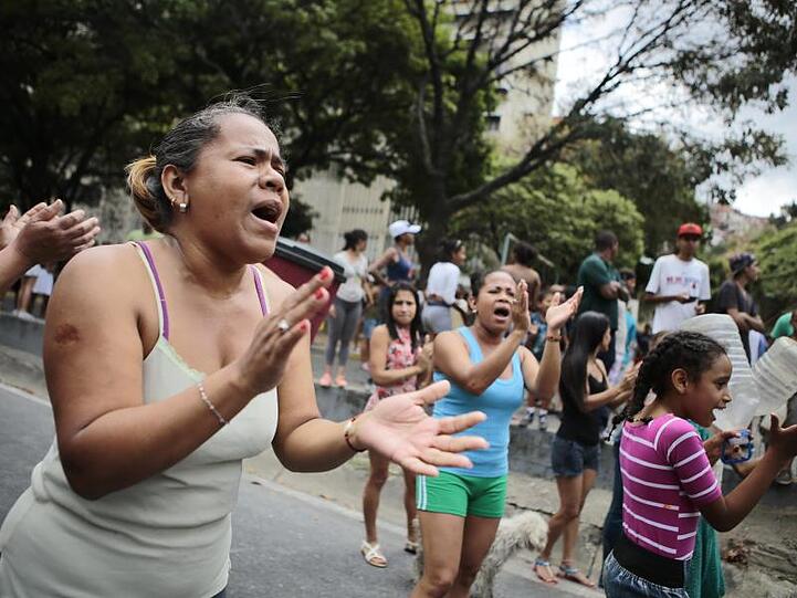 Frauen protestieren mit leeren Wasserkanistern auf einer Hauptverkehrsader der venezolanischen Hauptstadt gegen Wassermangel.