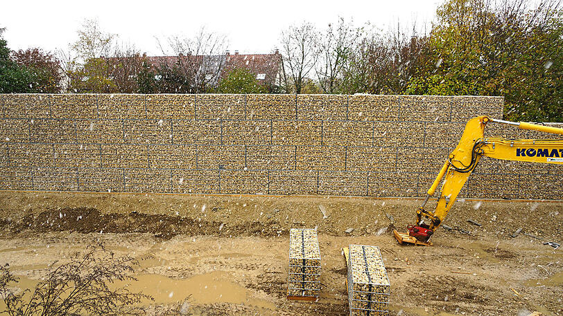 Der Mauer der Unterkunft. Im Hintergrund: Die Häuser der Anwohner.