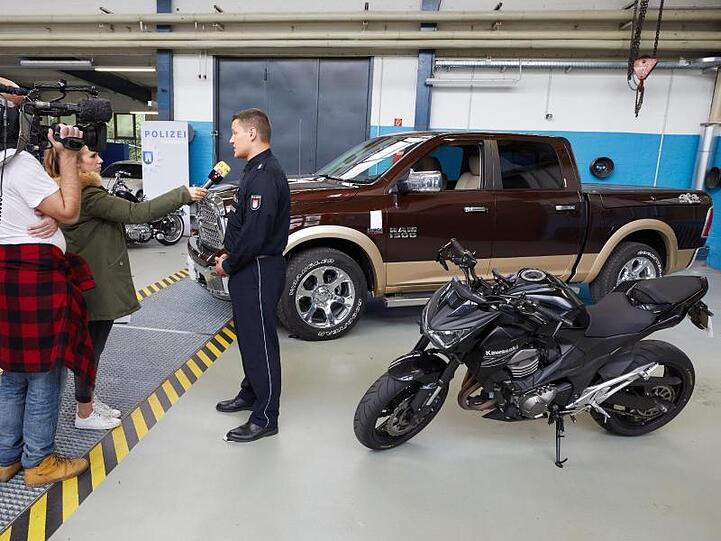 Pressekonferenz der Hamburger Kontrollgruppe "Autoposer": Im Hintergrund ein Chrysler Dodge RAM 1500 und eine Kawasaki Z800.