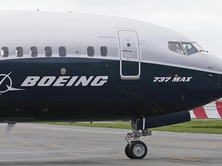 Ein Pilot winkt aus der Pilotenkabine eines Flugzeuges vom Typ Boeing 737 MAX auf dem Flughafen.