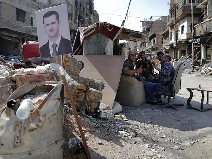 Syrische Soldaten haben einen Checkpoint der Armee im palästinensischen Flüchtlingslager von Jarmuk mit einem Bild des syrischen Präsidenten Baschar al-Assad versehen.