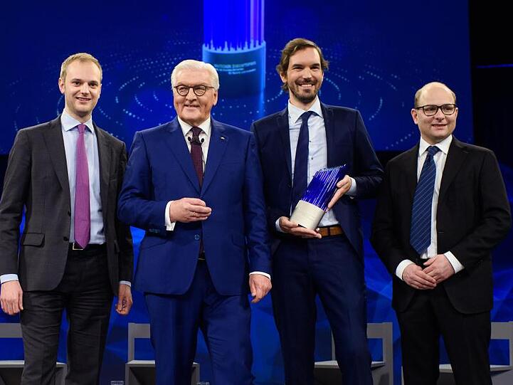 Frank-Walter Steinmeier (2.v.l.), Bundespräsident, steht gemeinsam mit den Preisträgern des deutschen Zukunftspreises, Alexander Rinke (l-r), Martin Klenk und Bastian Nominacher, nach der Verleihung auf der Bühne.