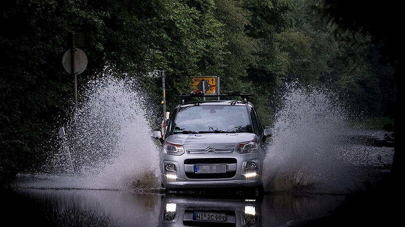 Ein Auto fährt über eine überschwemmte Straße in Hannover. Die Hochwasserlage in Niedersachsen entspannt sich allmählich. Doch es drohen neue Niederschläge.