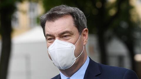 Markus Söder (CSU) trägt eine Schutzmaske während eines Gesprächs. Foto: Tobias Hase/dpa/Archivbild