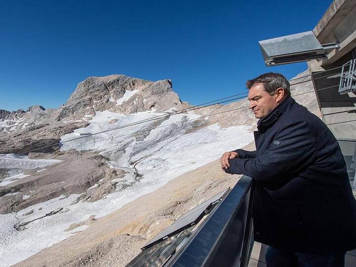 Markus Söder, Ministerpräsident von Bayern, steht während der Klimatour über einem Gletscher. Foto: Peter Kneffel/Archivbild