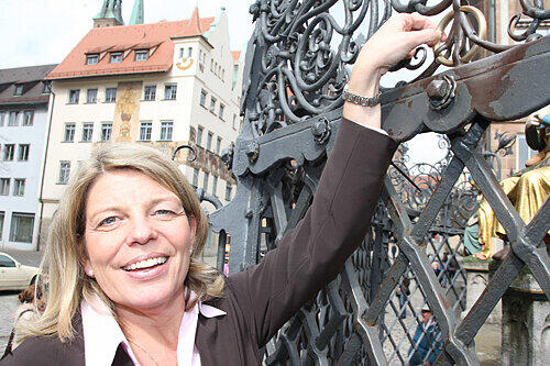 Yvonne Coulin (47), Nürnbergs neue Verkehrsdirektorin, dreht am goldenen Wunschring am Schönen Brunnen.