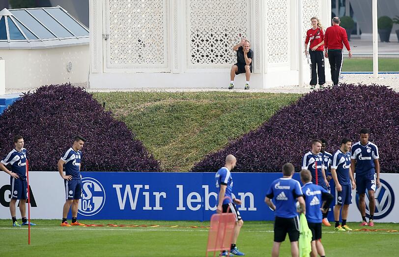 Auf dem Platz trainieren die Schalker, auf der anderen Seite des Zauns sitzt Arjen Robben und schaut bei Training zu. Die Bilder.