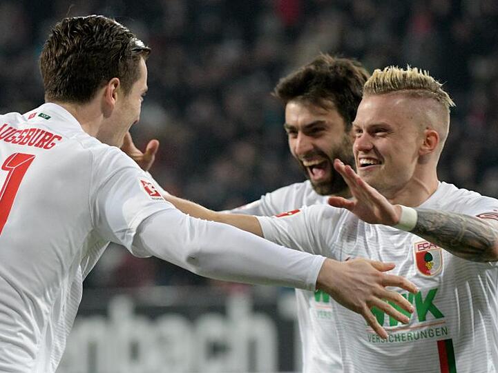 Augsburgs Michael Gregoritsch (l-r), Jan Moravek und Philipp Max jubeln über das 1:0 im Spiel gegen FC Bayern München. Foto: Stefan Puchner