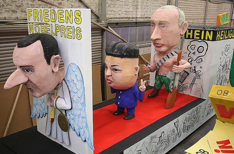 Die drei Länderchefs Assad, Kim-Jong Un und Putin (von l. nach r.) werden auf diesem Motivwagen thematisiert.