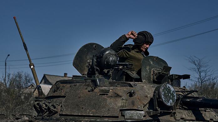 Ein ukrainischer Soldat gestikuliert auf einem gepanzerten Mannschaftstransportwagen an der Frontlinie in Bachmut.