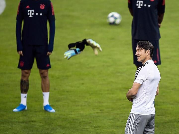 Trainer Niko Kovac vom FC Bayern München schaut auf die Handschuhe eines Torhüters, die durch die Luft fliegen. Foto: Angelos Tzortzinis/DPA